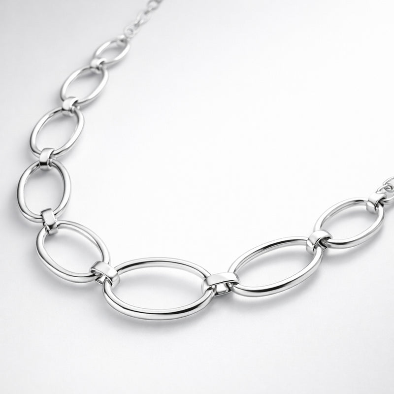 Angled studio view showing the elongated oval links and smooth silver tone finish of the necklace.
