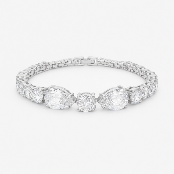 Studio view of a tennis bracelet featuring pear and round cut cubic zirconia set in rhodium plated brass.