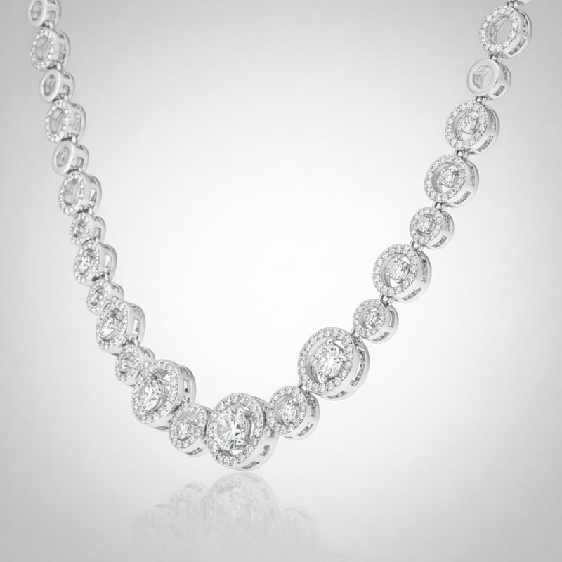 Angled studio view of a halo style silver tone necklace emphasizing the symmetrical stone arrangement.