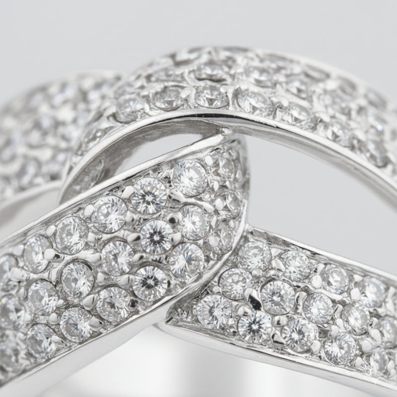 Close up view of an infinity pavé cubic zirconia ring in silver tone finish, highlighting the continuous infinity design and pavé set stones along the band.