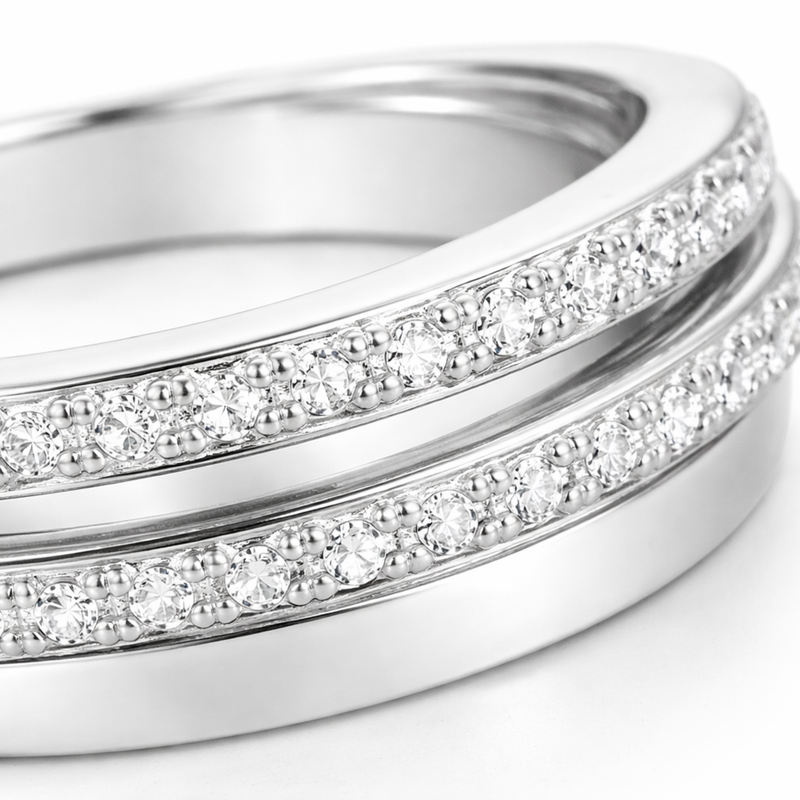 Close up view of the intertwined silver tone bands highlighting the pavé set round cut cubic zirconia stones arranged closely along two of the bands.