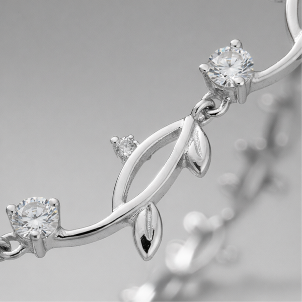 Close up detail of the leaf motif links with cubic zirconia accents and polished silver tone finish.