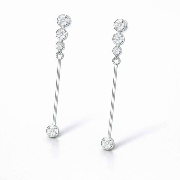 Close up side view of linear drop earrings featuring round cut cubic zirconia stones in a silver tone setting.