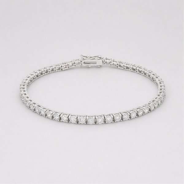 Studio view of a classic silver tone tennis bracelet featuring a continuous row of round cut cubic zirconia stones and a secure box clasp closure.