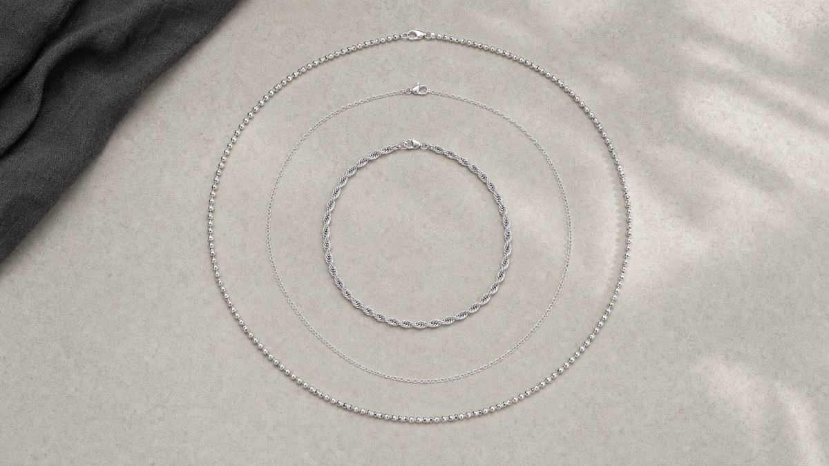 Three separate silver-tone twisted, cable, and beaded chain necklaces arranged in concentric loops