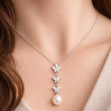 Worn view of the butterfly drop cubic zirconia and pearl pendant illustrating length, proportions, and movement.