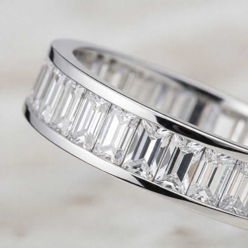Angled view of the channel set baguette cut cubic zirconia ring emphasizing the straight baguette cut stones and smooth silver tone finish.