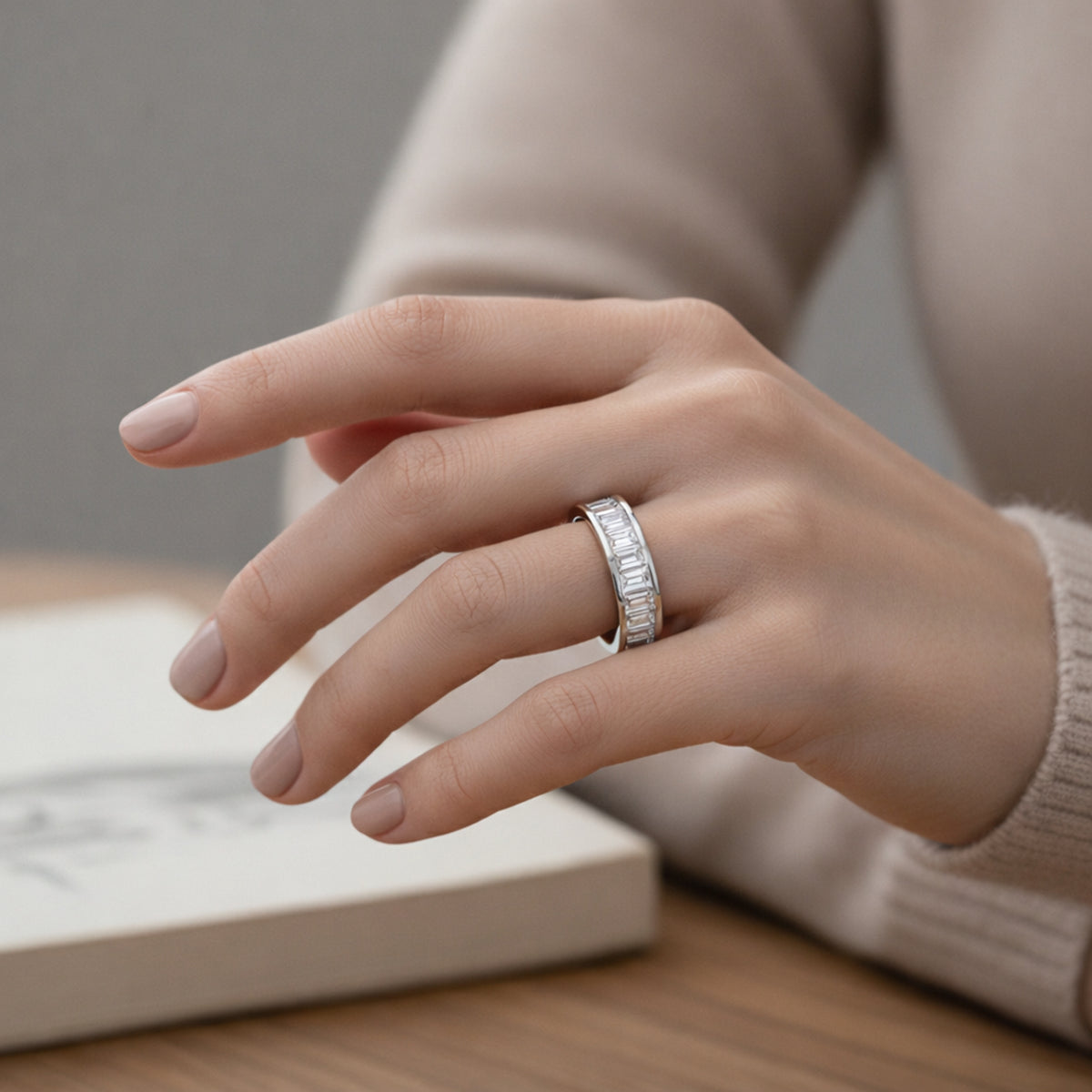 Worn on hand view of a channel set baguette cut cubic zirconia ring in silver tone finish, illustrating proportions and everyday wear appearance.
