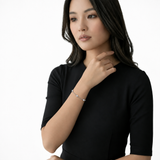 Model wearing clara clear station bracelet in silver tone with a black top.