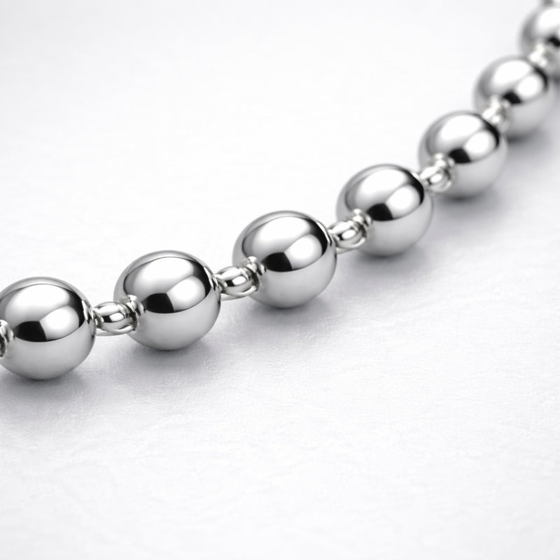 Macro view highlighting the smooth spherical beads and reflective silver tone finish of the necklace.