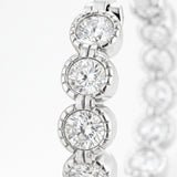 Close up view of silver tone hoop earrings focusing on the round cubic zirconia stones and the detailed polished metal setting.