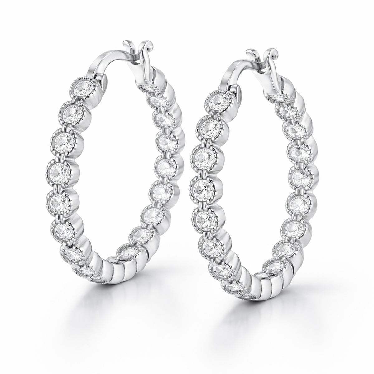 Studio side view of classic silver tone hoop earrings featuring multiple round cubic zirconia stones evenly set along the hoop.