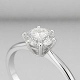 Side profile close up view of the classic solitaire cubic zirconia ring focusing on the raised prong setting, polished silver tone band and the round cut center stone.
