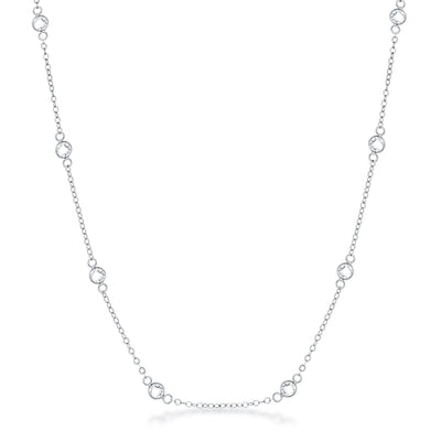 Front facing studio view of a silver tone station necklace featuring evenly spaced bezel set stones along a delicate chain.