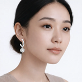 Model shot captures drop hoop earrings with cubic zirconia, styled with an off-shoulder neckline so the earrings frame the face with high-polish shine.