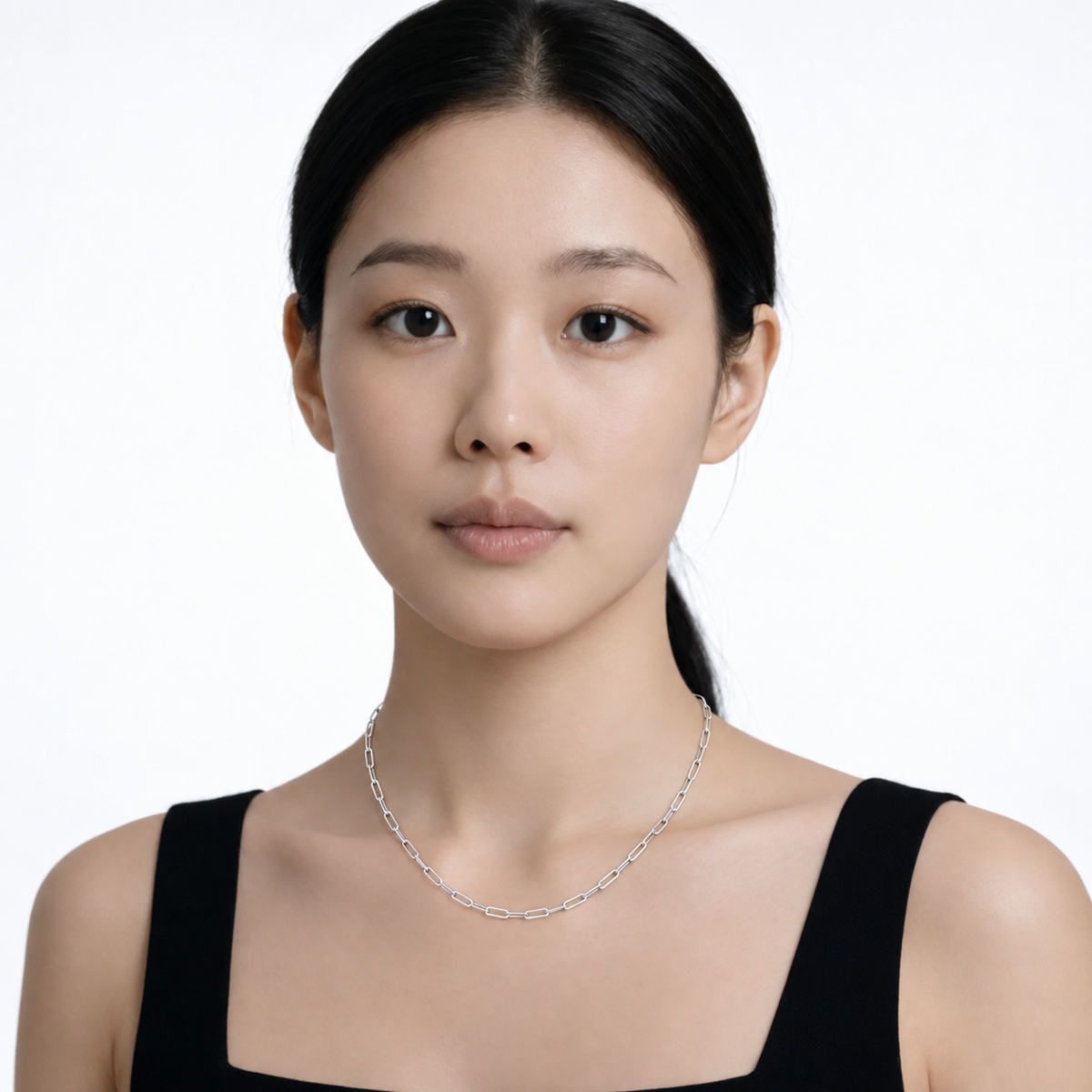 Model wearing endless whisper paperclip chain necklace in silver tone with a black top.