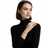 Model view shows a halo-slider bracelet with a round center cluster and a line of clear stones, gleaming over a black ribbed sleeve in bright silver tone.