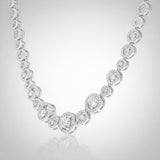 Angled studio view of a halo style silver tone necklace emphasizing the symmetrical stone arrangement.