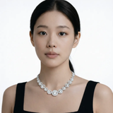 Model shot captures a silver tone halo style cubic zirconia necklace, styled with a black sleeveless dress so the chain drapes cleanly along the collarbone.