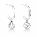 Close-up view of hoop earrings with a polished silver tone finish, each featuring a round cubic zirconia drop in a bezel-style setting.