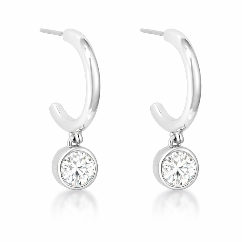 Close-up view of hoop earrings with a polished silver tone finish, each featuring a round cubic zirconia drop in a bezel-style setting.