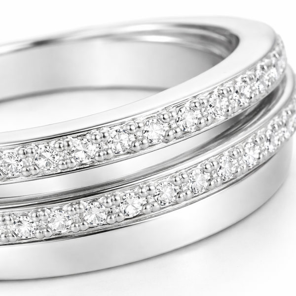 Close up view of the intertwined silver tone bands highlighting the pavé set round cut cubic zirconia stones arranged closely along two of the bands.