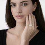 Model view showcases a silver tone intertwined band ring with cubic zirconia, styled with a tailored black top so the ring sparkles along the fingertips.