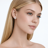 Model wearing jenny round clear stone stud earrings in silver tone with a neutral off-shoulder top.