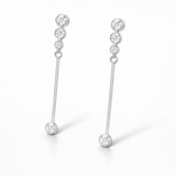 Close up side view of linear drop earrings featuring round cut cubic zirconia stones in a silver tone setting.