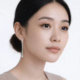 Model shot captures linear drop earrings with cubic zirconia, styled with an off-shoulder neckline so the earrings frame the face with high-polish shine.