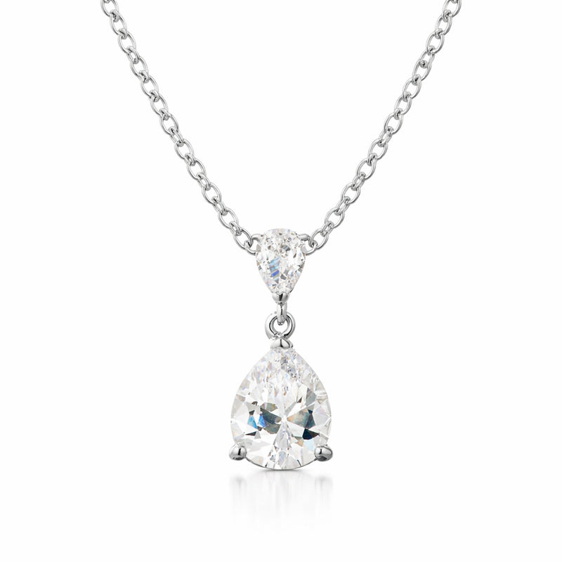 Studio view of a silver tone pear shaped drop pendant featuring a larger cubic zirconia suspended from a smaller pear shaped connector.