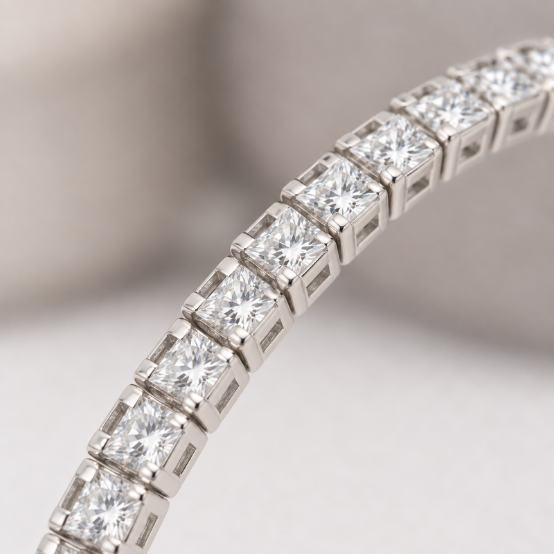 Close-up of clear square stones and individual silver-tone settings on a curved bracelet section.