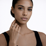 On-model portrait highlights a rope style solitaire cubic zirconia ring, styled with a black sleeveless top so the ring sparkles along the fingertips.
