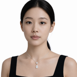 Model wearing round and pear clear stone drop pendant in silver tone with a black top.