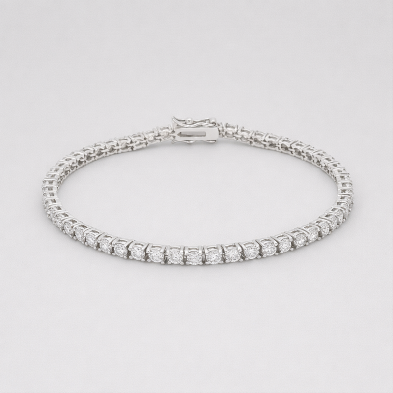 Studio view of a classic silver tone tennis bracelet featuring a continuous row of round cut cubic zirconia stones and a secure box clasp closure.